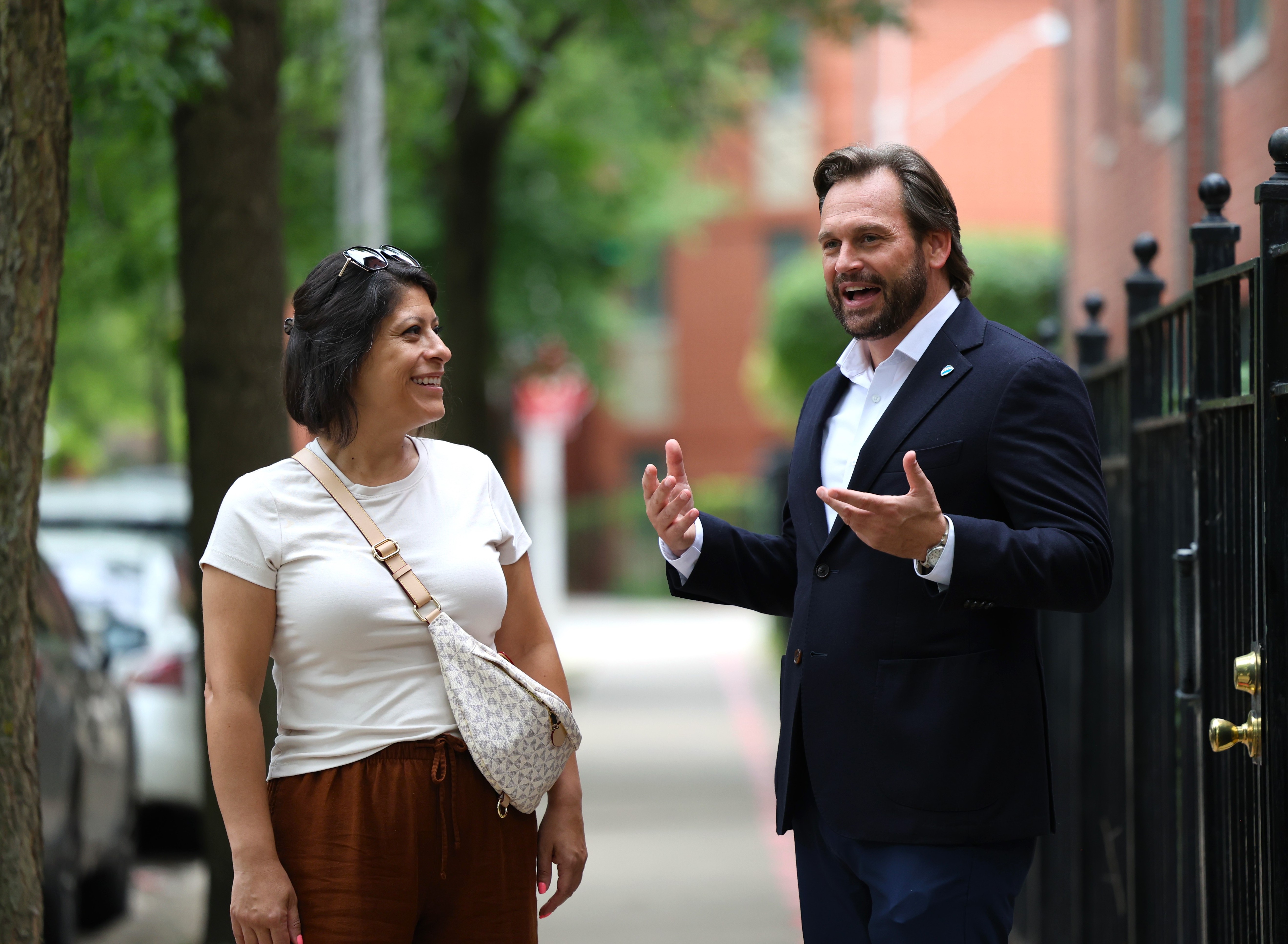 Dan Balanoff talking with a client on a tree-lined Chicago street