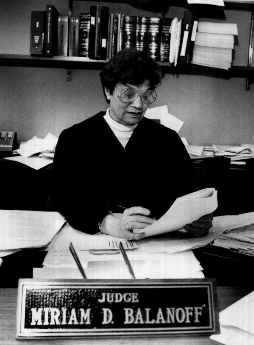 Judge Miriam D. Balanoff at her desk in chambers, her nameplate in the foreground
