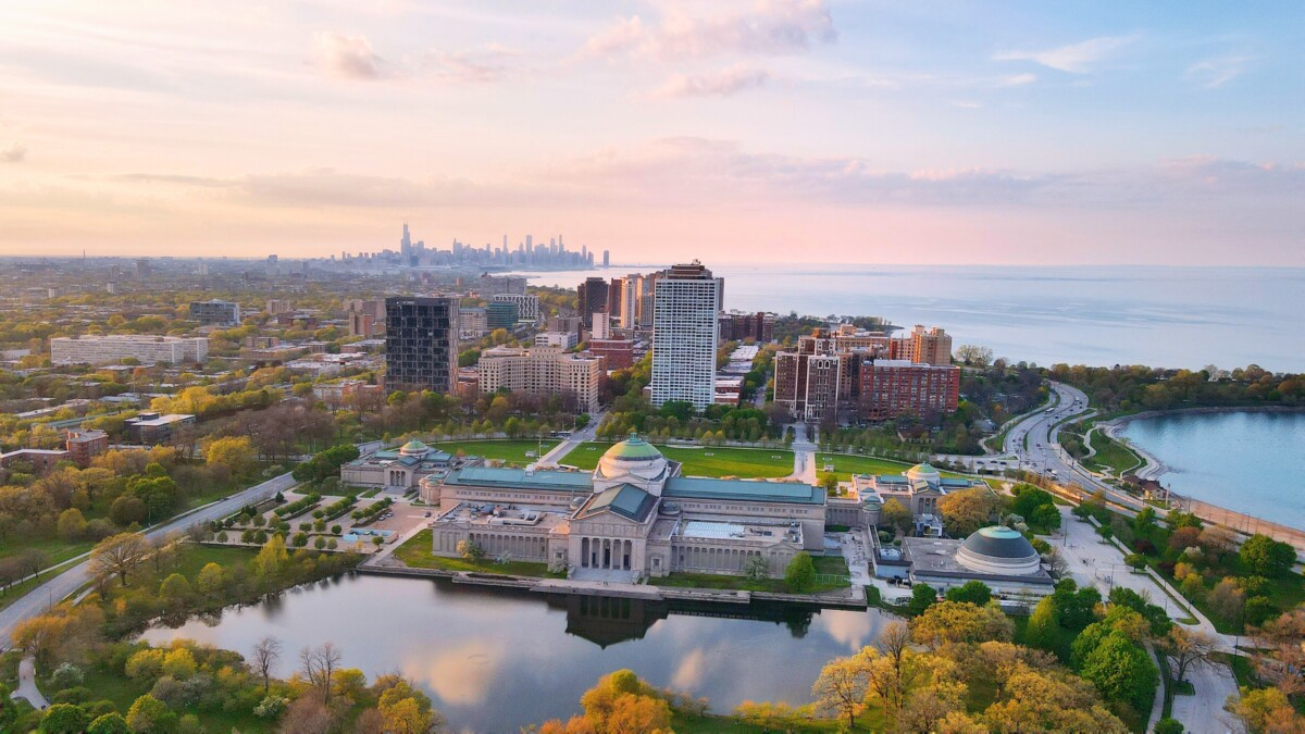 Aerial view of the Museum of Science and Industry with the Chicago skyline beyond